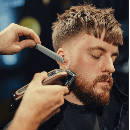 Barber trimming client beard with Wahl 5-Star trimmer